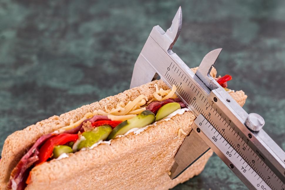 Free Image of Caliper Holding Sandwich With Vegetables and Meat 