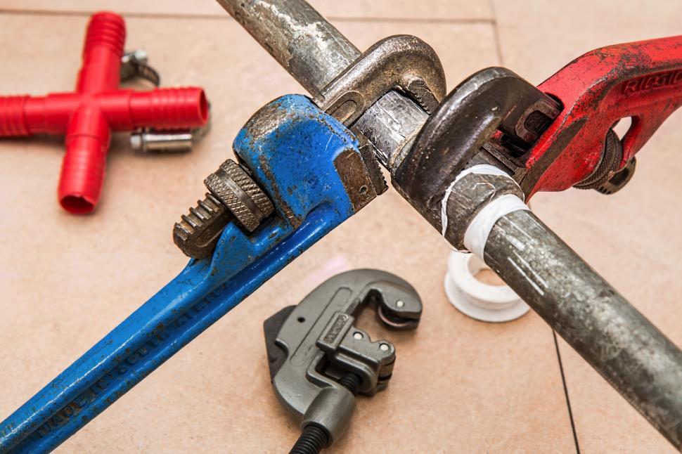Free Image of Assorted Tools Including Wrench and Pipe Wrench on Tile Floor 