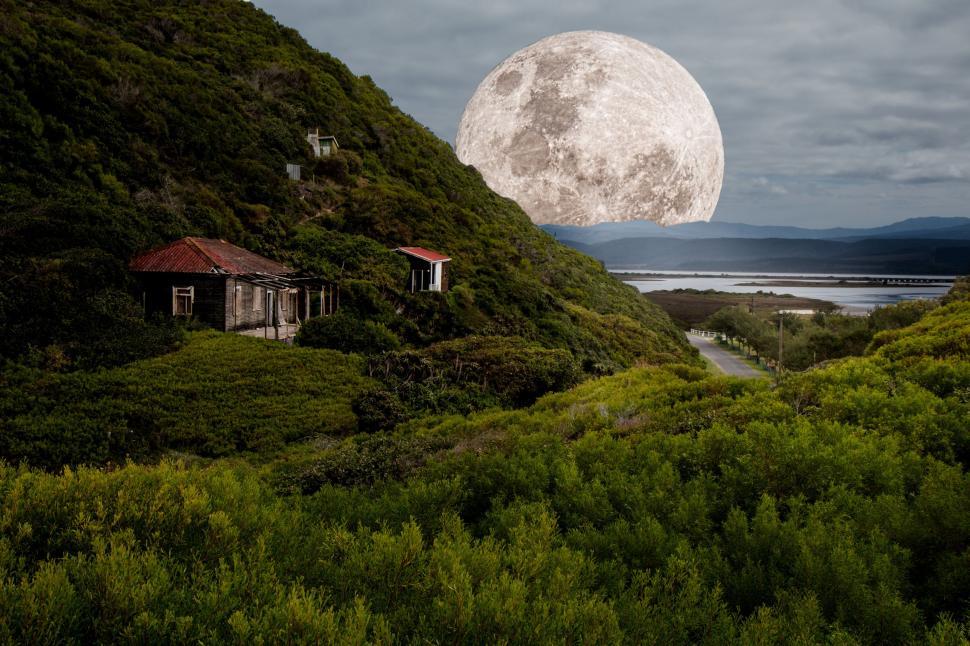 Free Image of Full Moon Rising Over Mountain With House in Foreground 