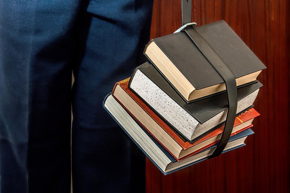 Free Image of Person Holding a Stack of Books 