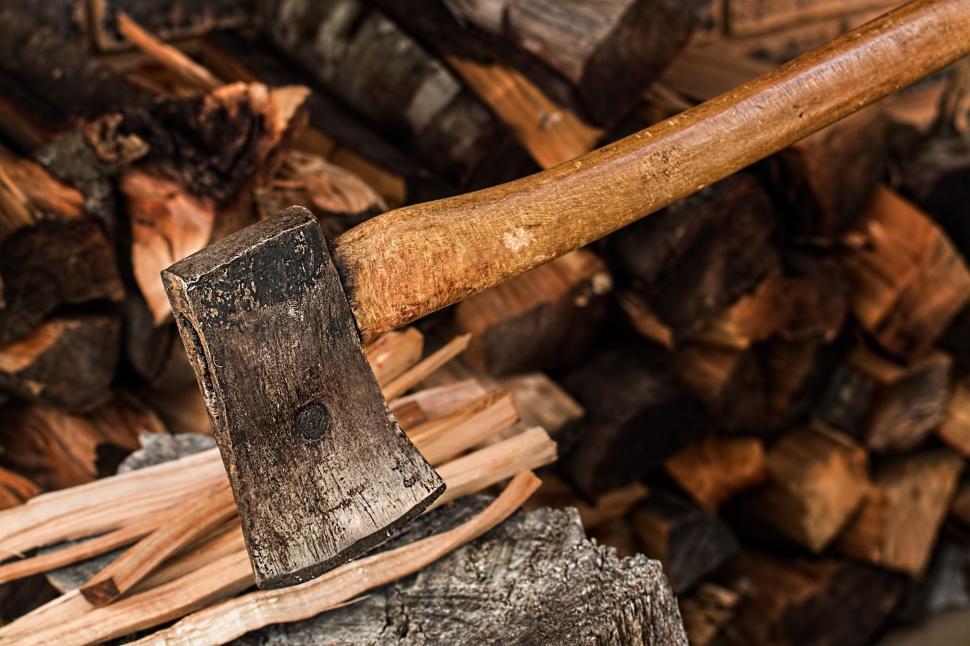 Free Image of Old Axe Stuck in Pile of Wood 