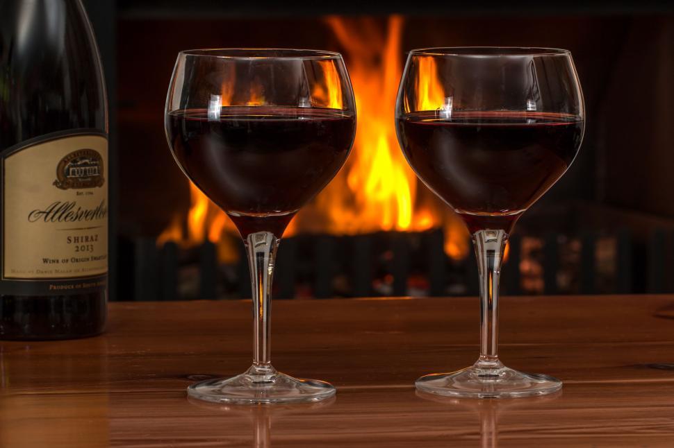 Free Image of red wine glasses log fire red wine alcohol drink celebration restaurant glass wineglass beverage celebrate shiraz romantic lifestyle bottle romance relaxation ambience relaxing warmth relax atmosphere 