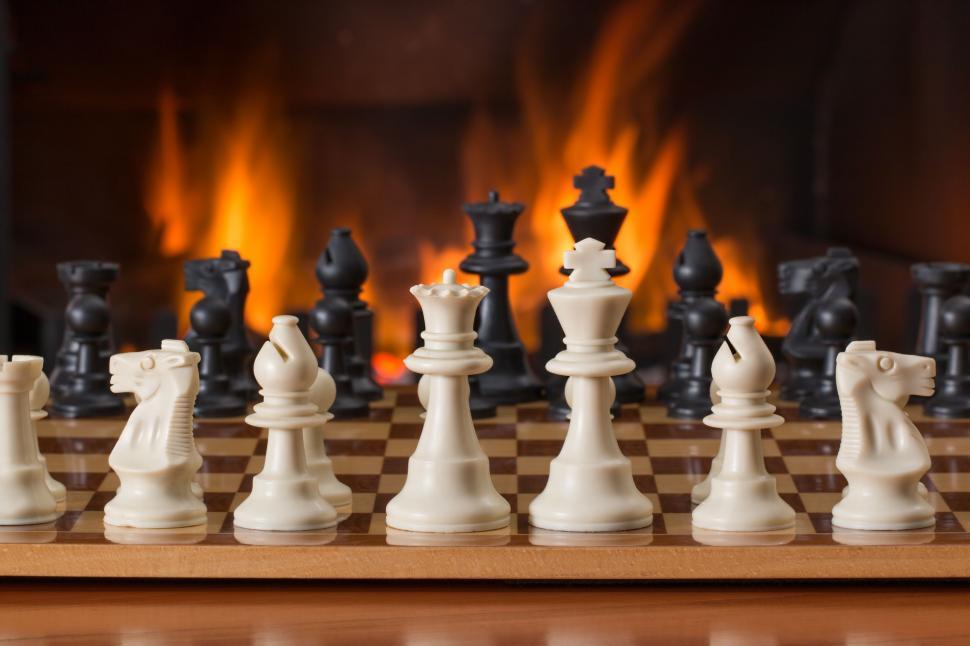 Free Image of chess board game fireside strategy play competition leisure game board piece move vintage winner log fire winter hearth recreation pawn challenge white intelligence king battle knight queen bishop power chessboard tournament flames warmth 