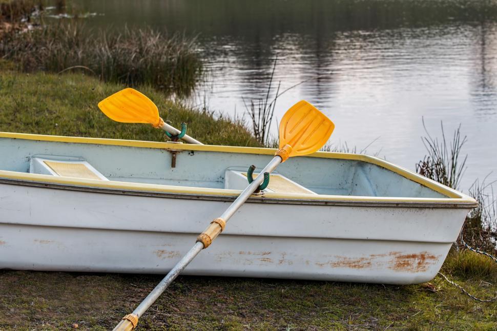 Free Image of Small Boat With Two Oars on the Shore 
