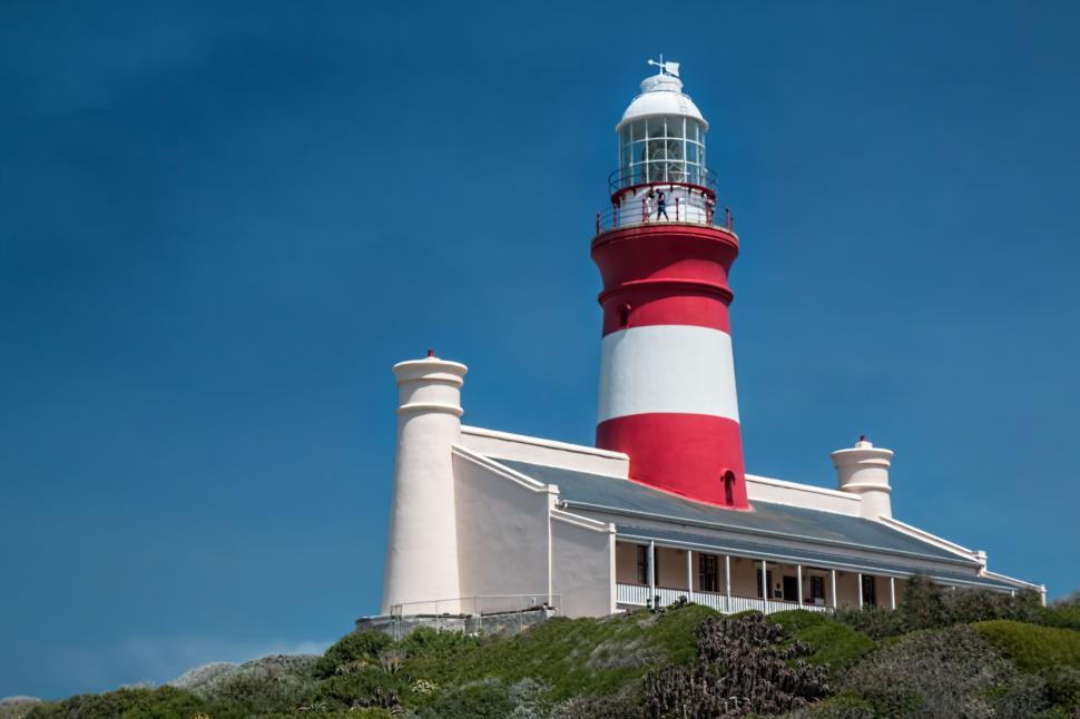 Free Image of Red and White Lighthouse on Hill 