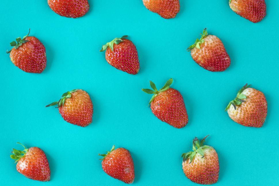 Free Image of Flay lay of strawberries on greenish blue surface 