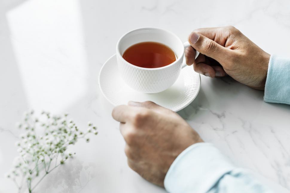 Free Image of Close up of a hands and a cup of tea 