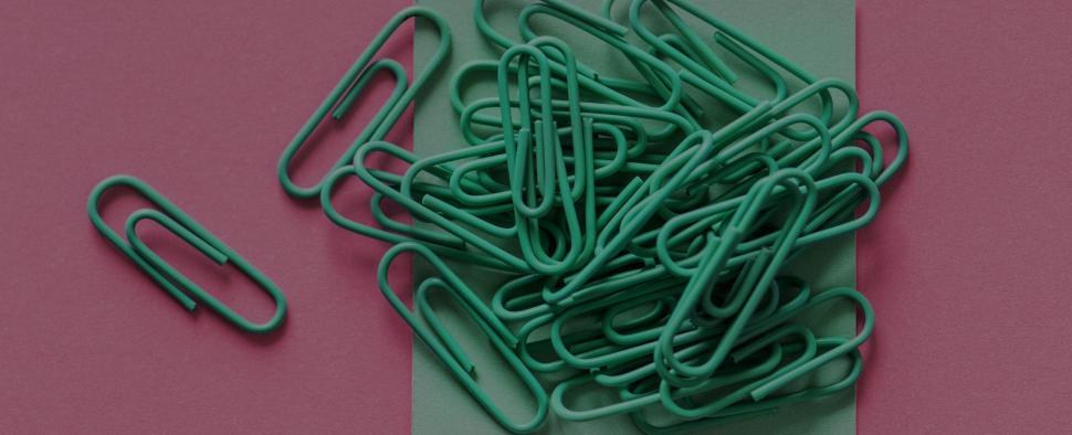 Free Image of Green paperclips on red surface 