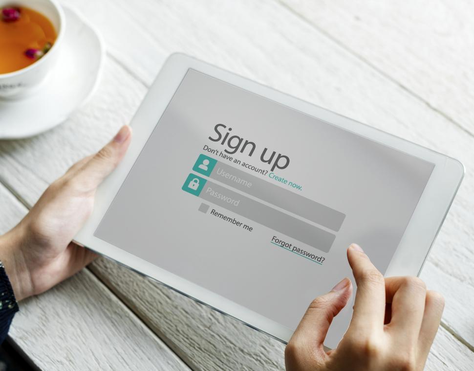 Free Image of Close up of a woman s hands holding a tablet PC with sign up page 