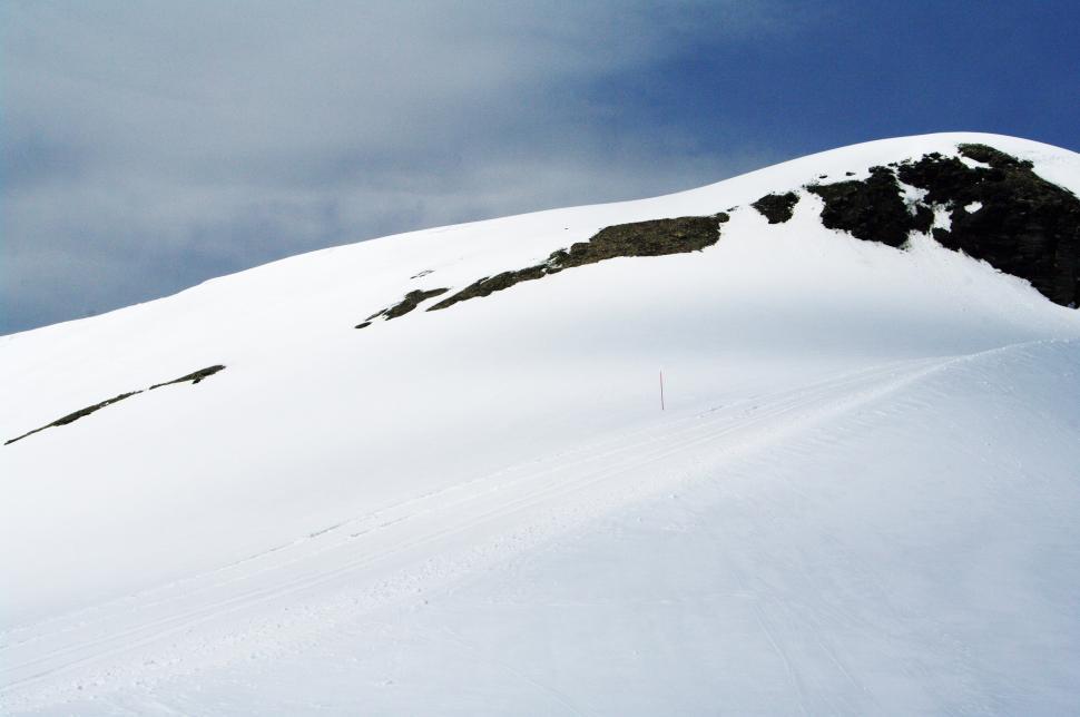 Free Image of Man Snowboarding Down Snow-Covered Slope 