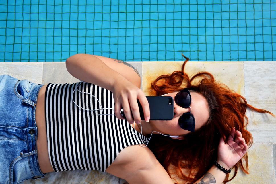 Download Free Stock Photo of Woman lying down near swimming pool 