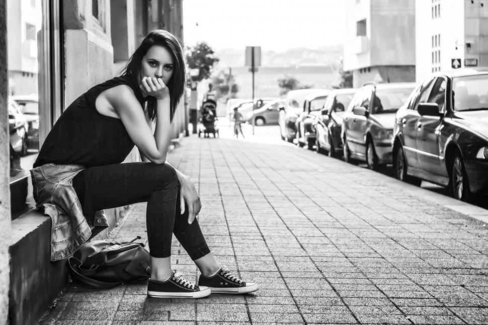 Free Image of Young woman Sitting on Pavement 