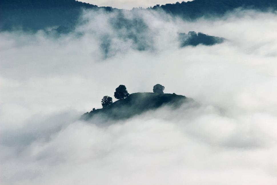 Free Image of Passing clouds engulf a mountain  