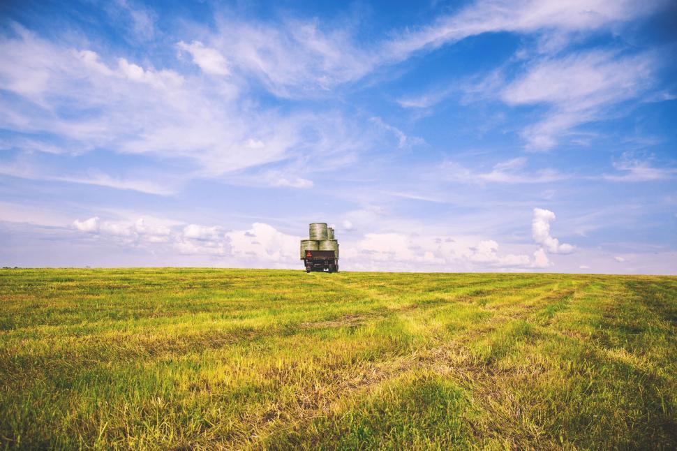 Free Image of Farmland with truck of hay bales 