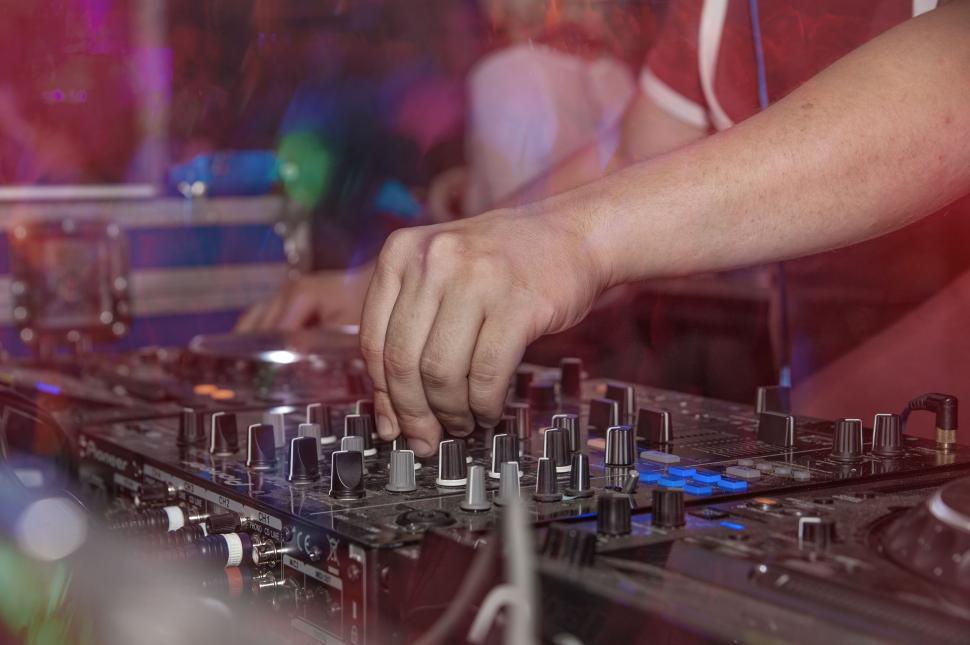 Free Image of DJ hands on mixing knobs  