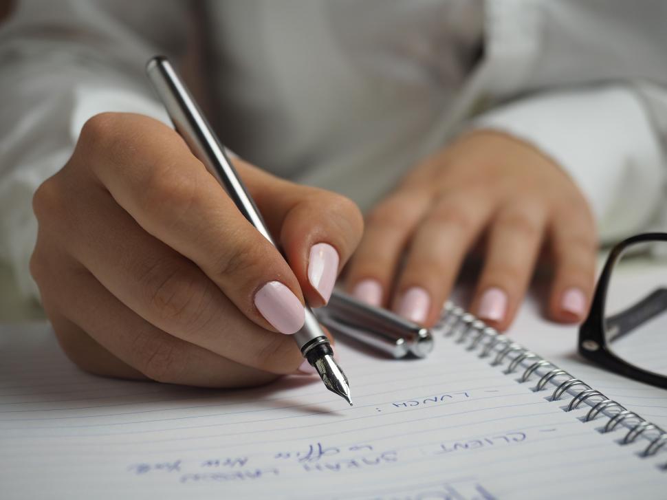 Free Image of Woman Writing on Notepad  