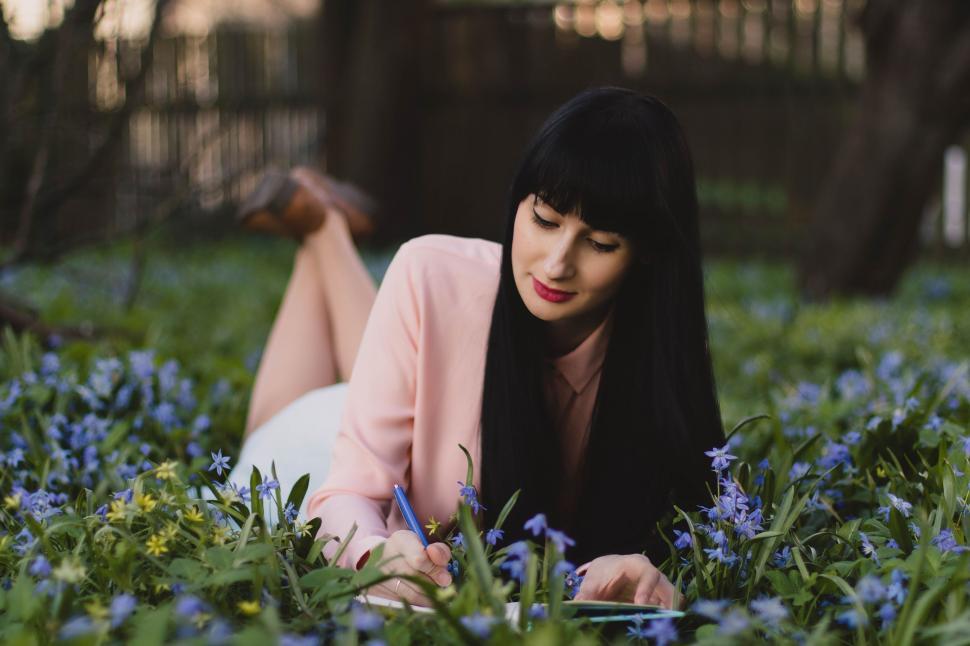 Free Image of Woman Lying And Writing in Park 