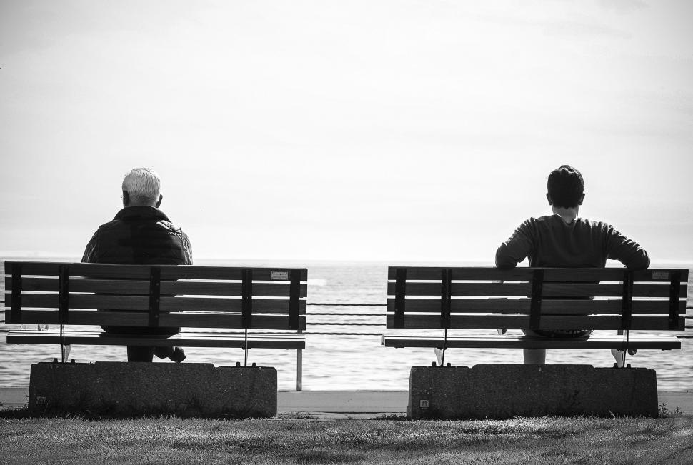 Free Image of Two Different Aged Men Sitting on Two Benches  
