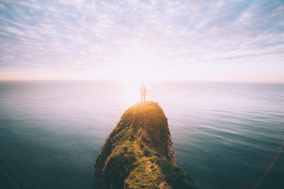Free Image of Alone Man on cliff edge of Ocean  