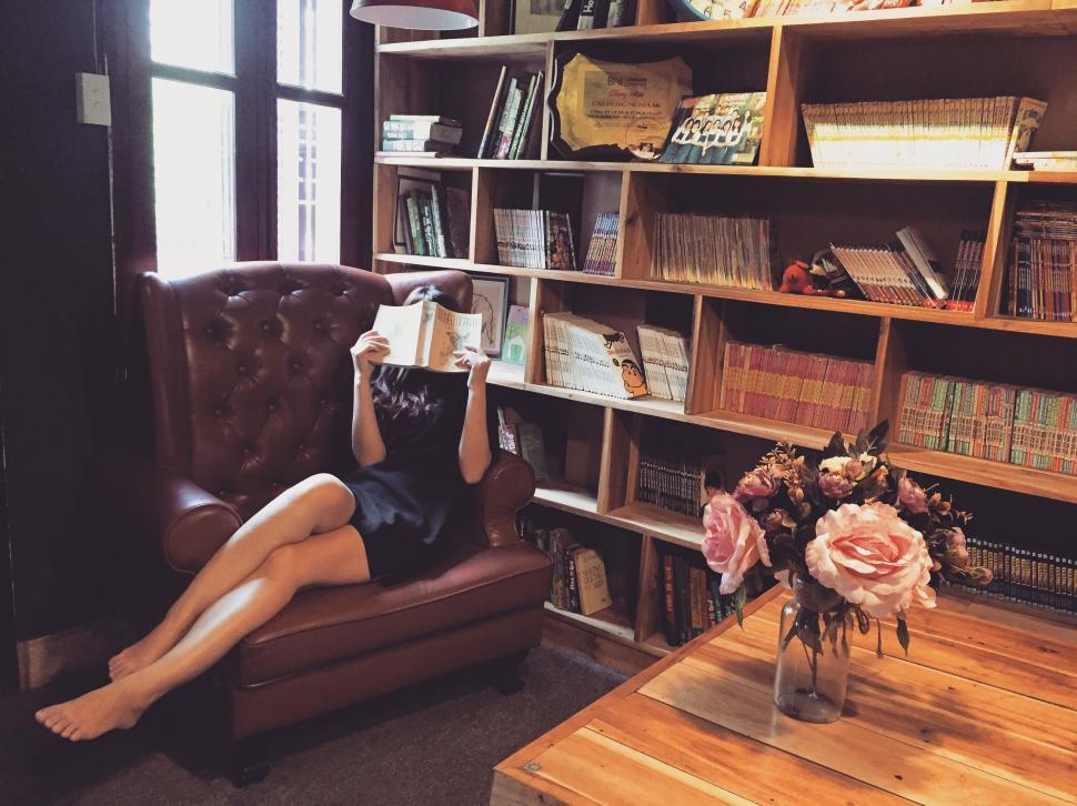 Free Image of Woman reading a book in home library 