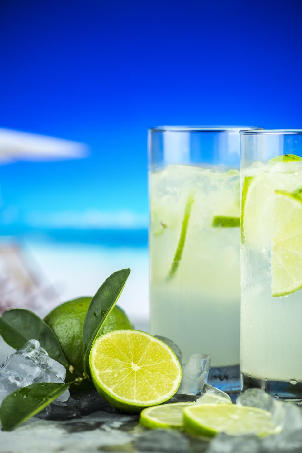 Free Image of Close up of two glasses full of chilled mojito, beach scene  
