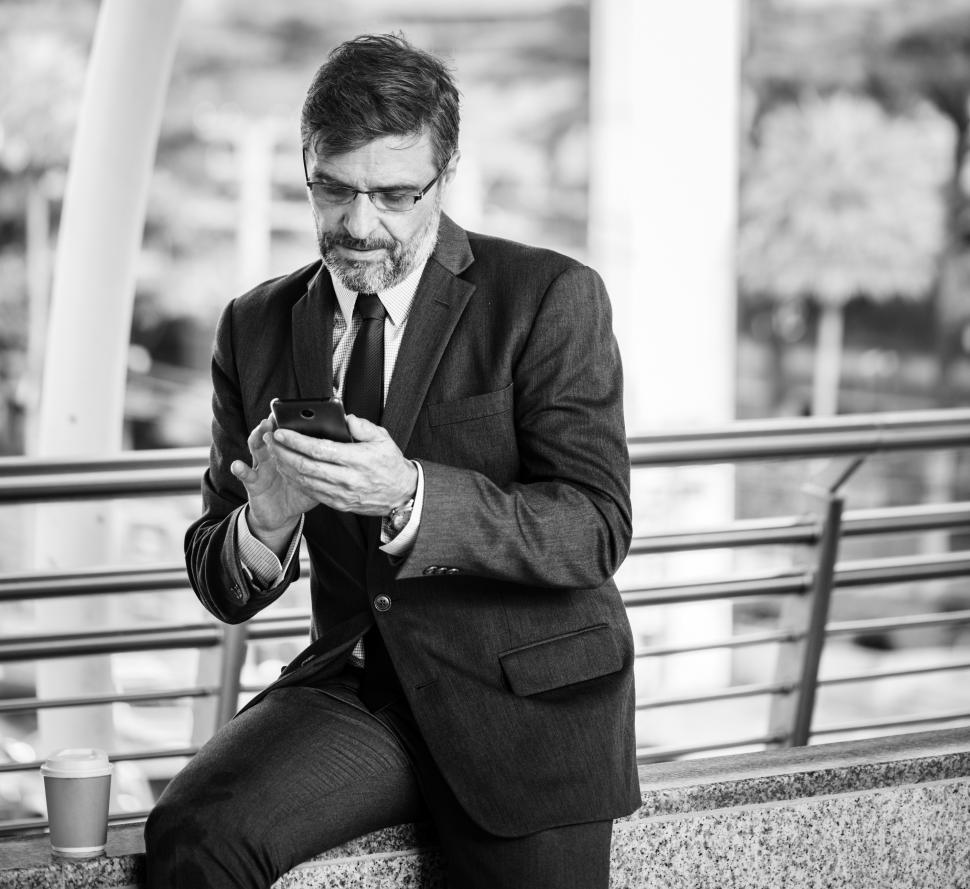 Free Image of A bearded businessman operating his mobile phone - black and white photo 