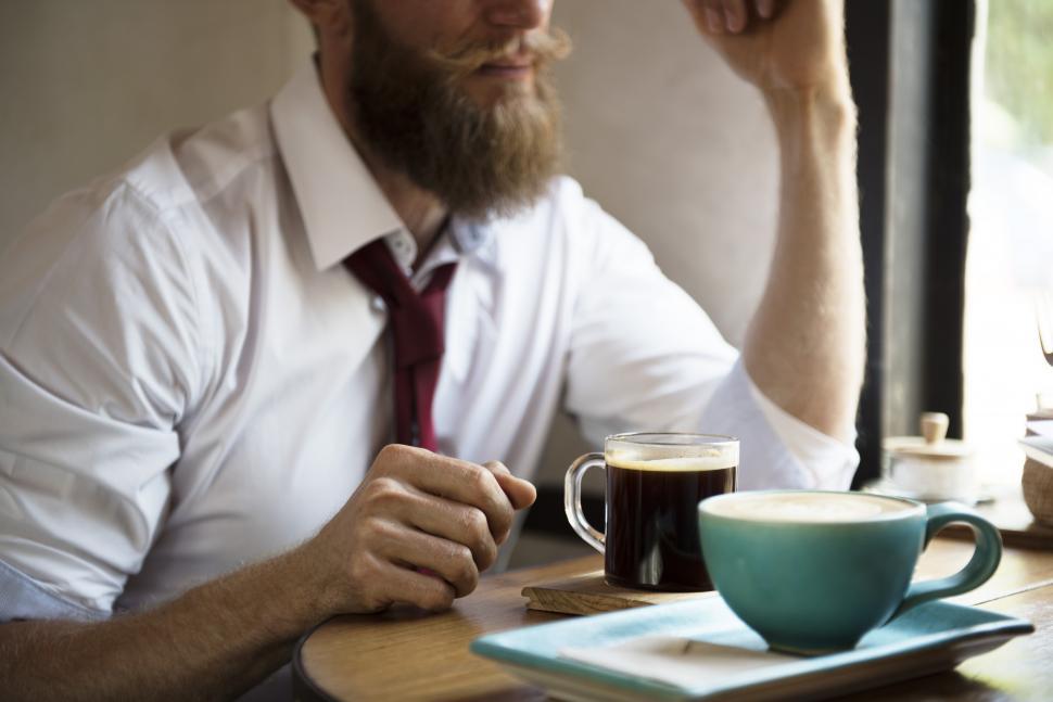 Free Image of A bearded business man at a cafe table, casual dress 