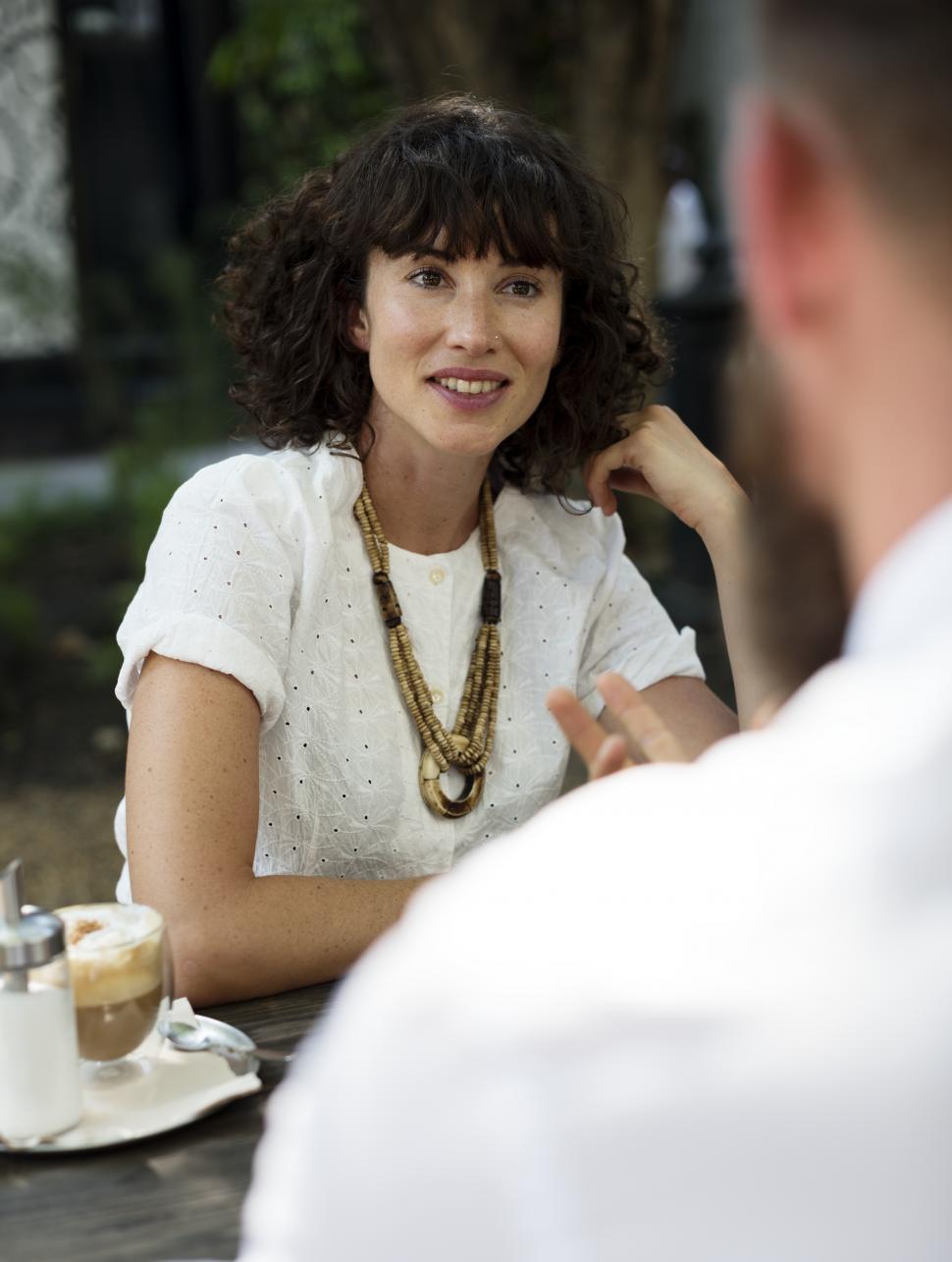 Free Image of Close up of two business people discussing at an outdoor restaurant table 
