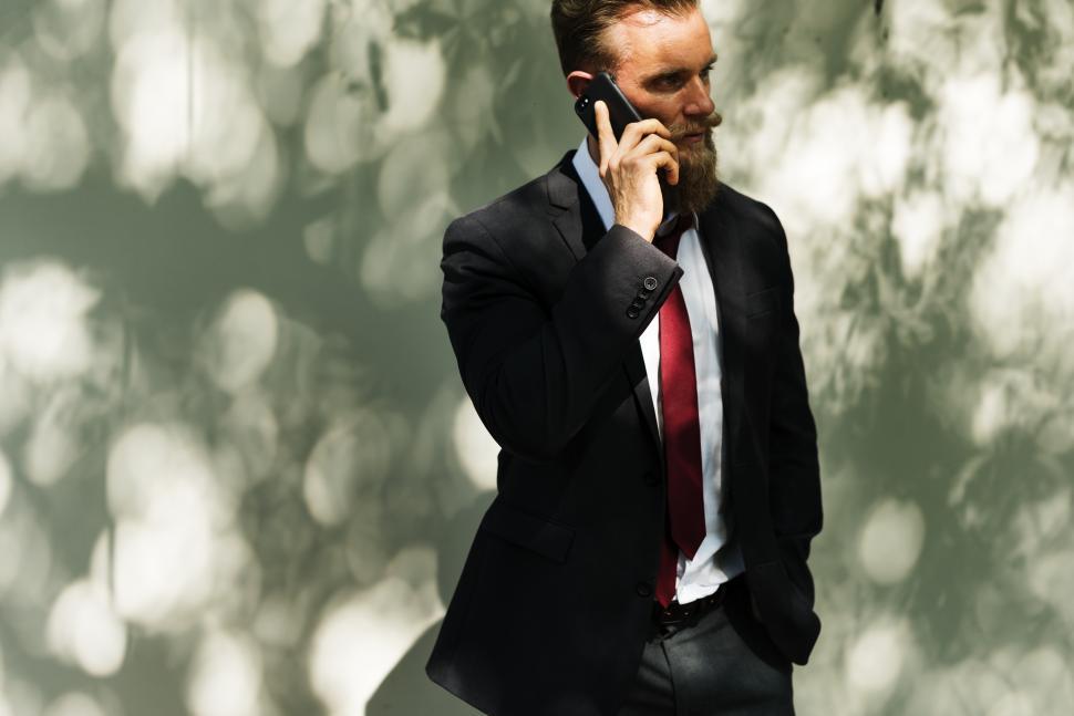Free Image of A bearded Caucasian man talking on the phone outside 
