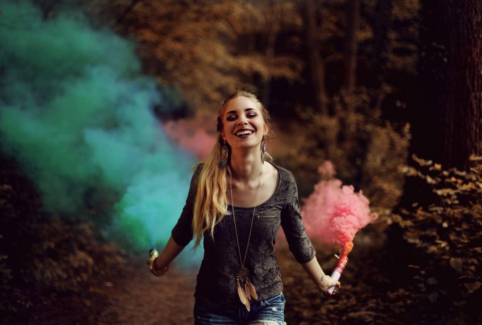 Free Image of Smiling Woman with colorful smoke bombs  