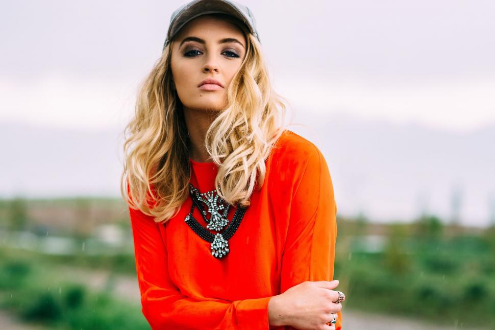 Free Image of Female Model in orange top and hat - eye contact  