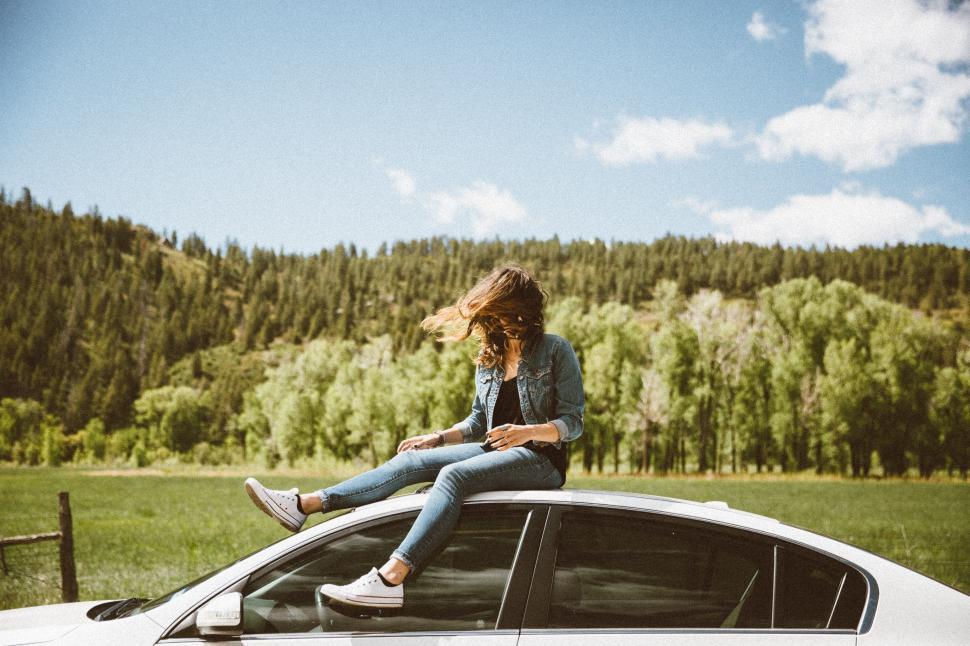 Free Image of Woman Sitting on Car  