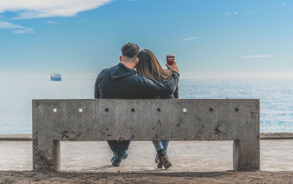 Free Image of Couple on concrete bench near ocean 