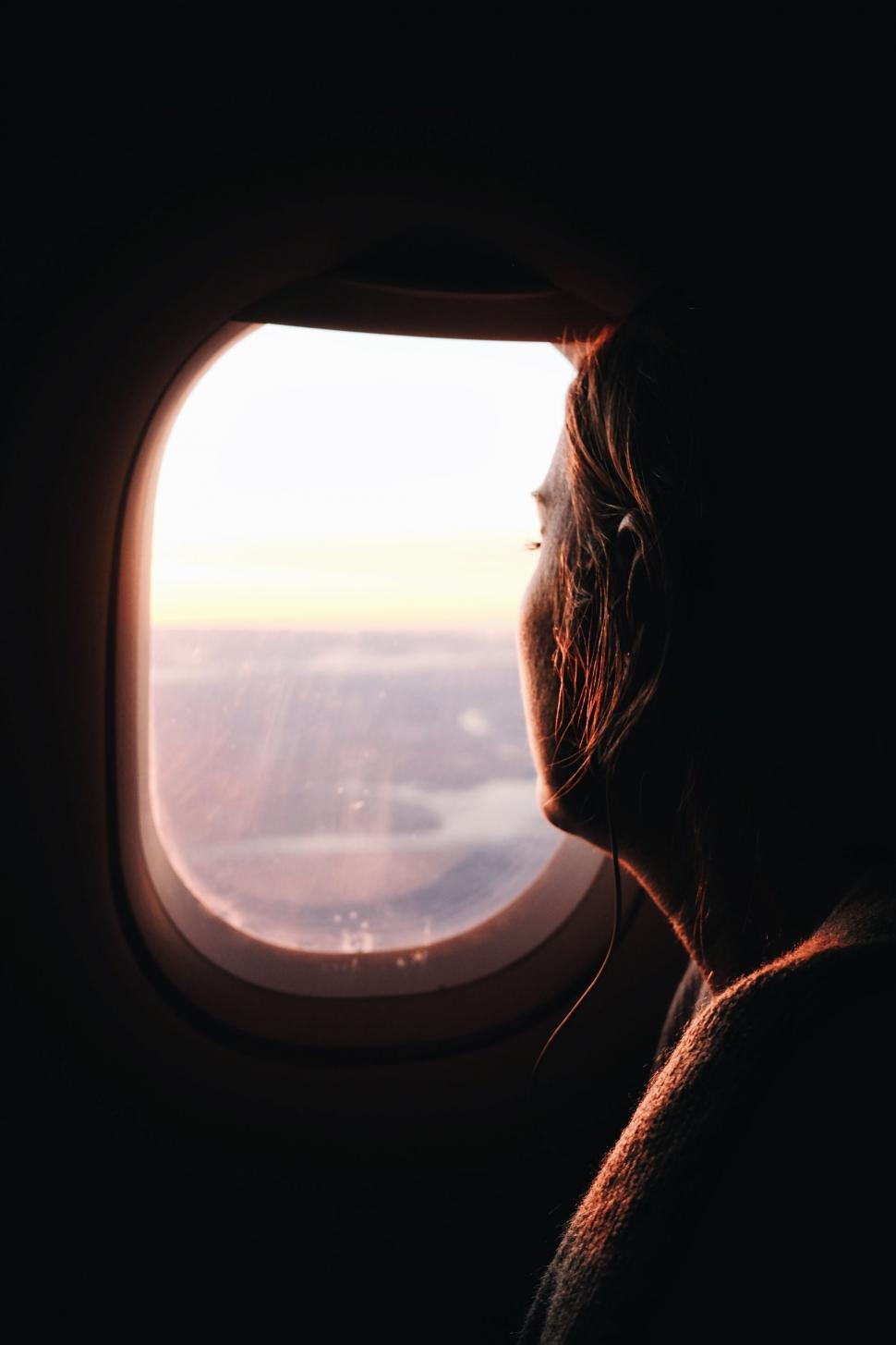 Free Image of Silhouette view of woman near airplane window  