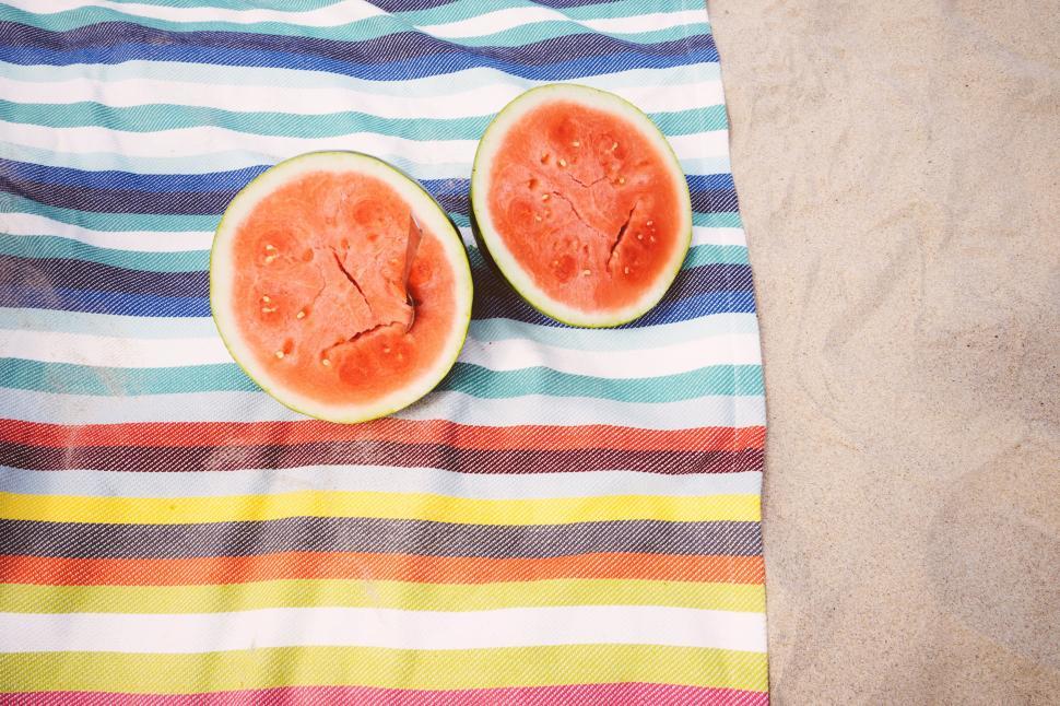 Free Image of Sliced Watermelon on beach sand 
