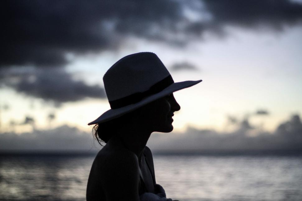 Free Image of Silhouette of woman in hat at the beach  