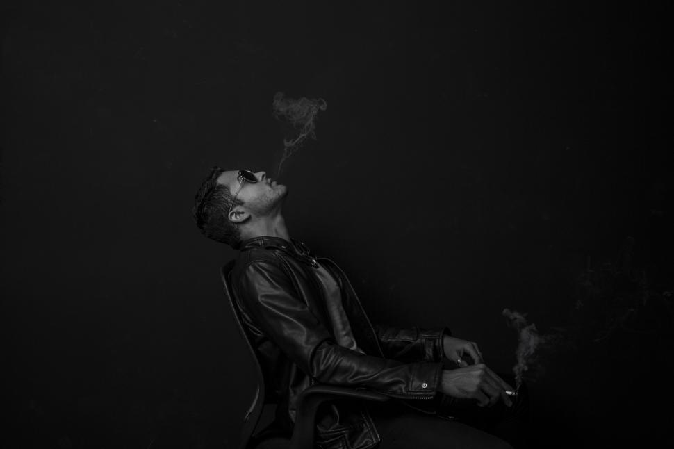 Free Image of Man in Sunglasses smoking on Chair on black background  