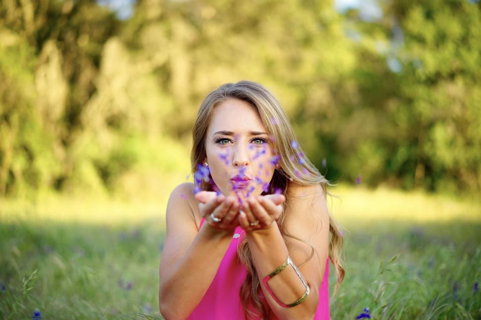 Free Image of Woman Blowing Flower Petals  