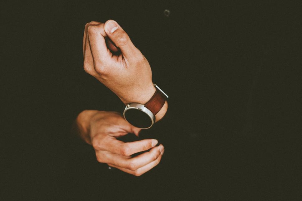 Free Image of Hands and Wristwatch on Black Background  