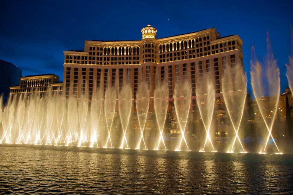 Free Image of Large Fountain Illuminated at Night in Front of Hotel 