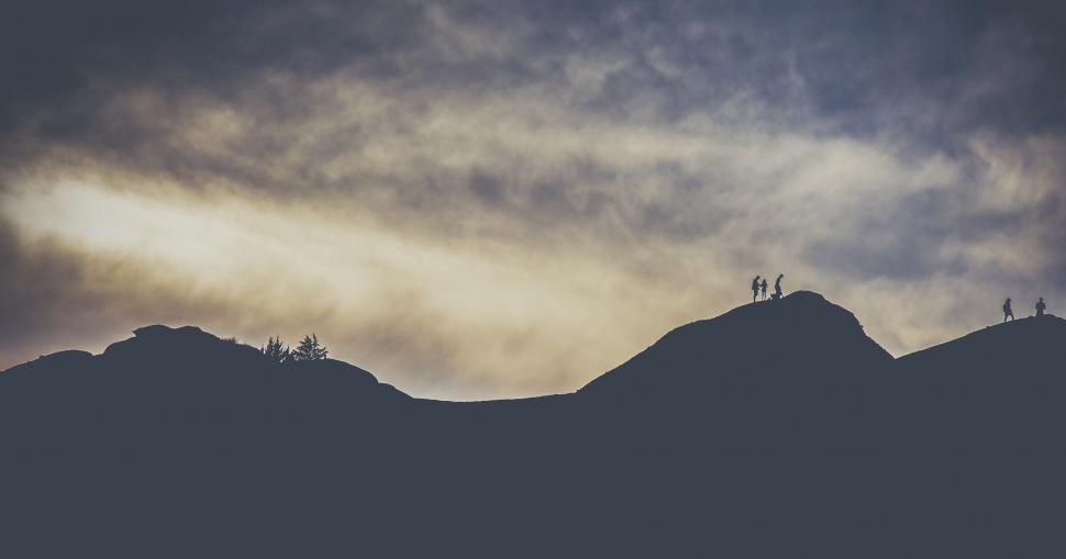 Free Image of Hikers on Mountain with sunset sky  