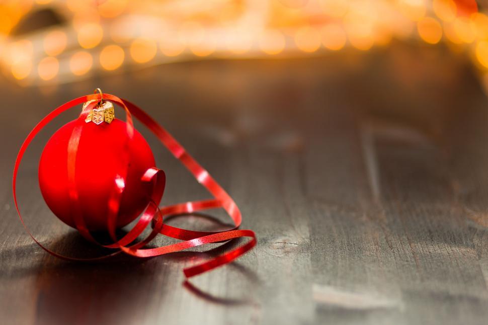 Free Image of Red Christmas Ball with yellow bokeh lights in the background 