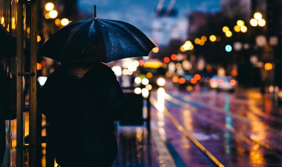 Free Image of Night view of man under umbrella  