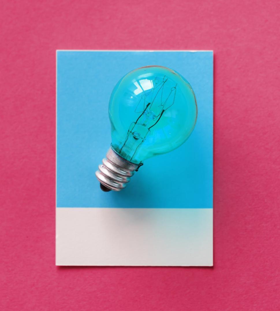 Free Image of Flat lay a small lightbulb on blue cardboard frame 