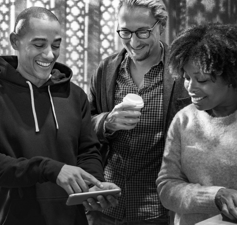 Free Image of Multiethnic colleagues looking at mobile phone - black and white 