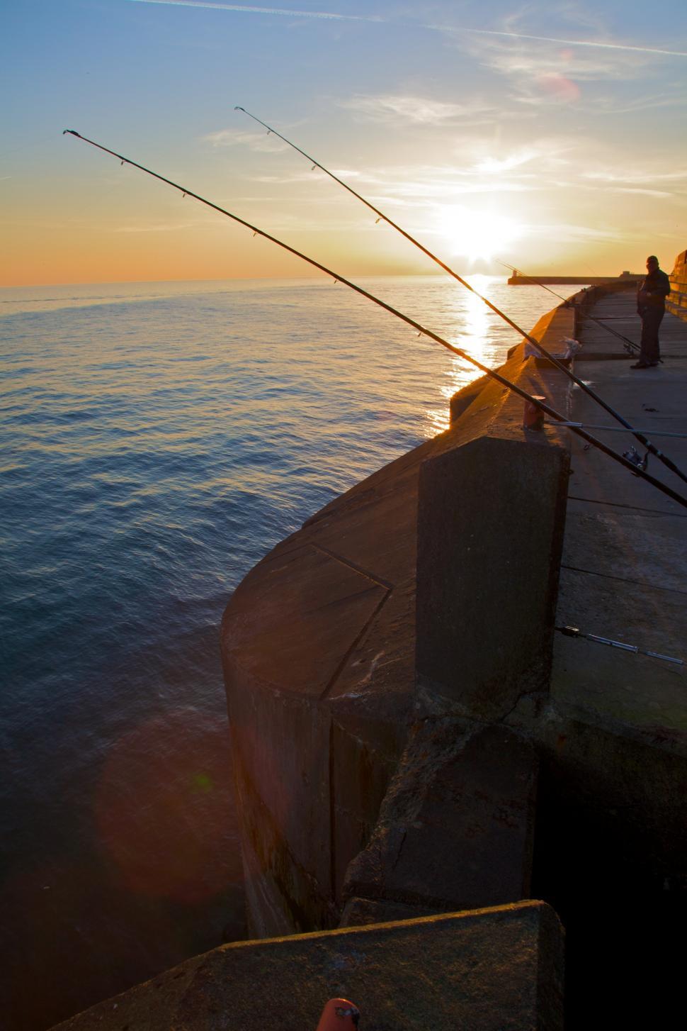 Free Image of Person Fishing on Pier Edge 
