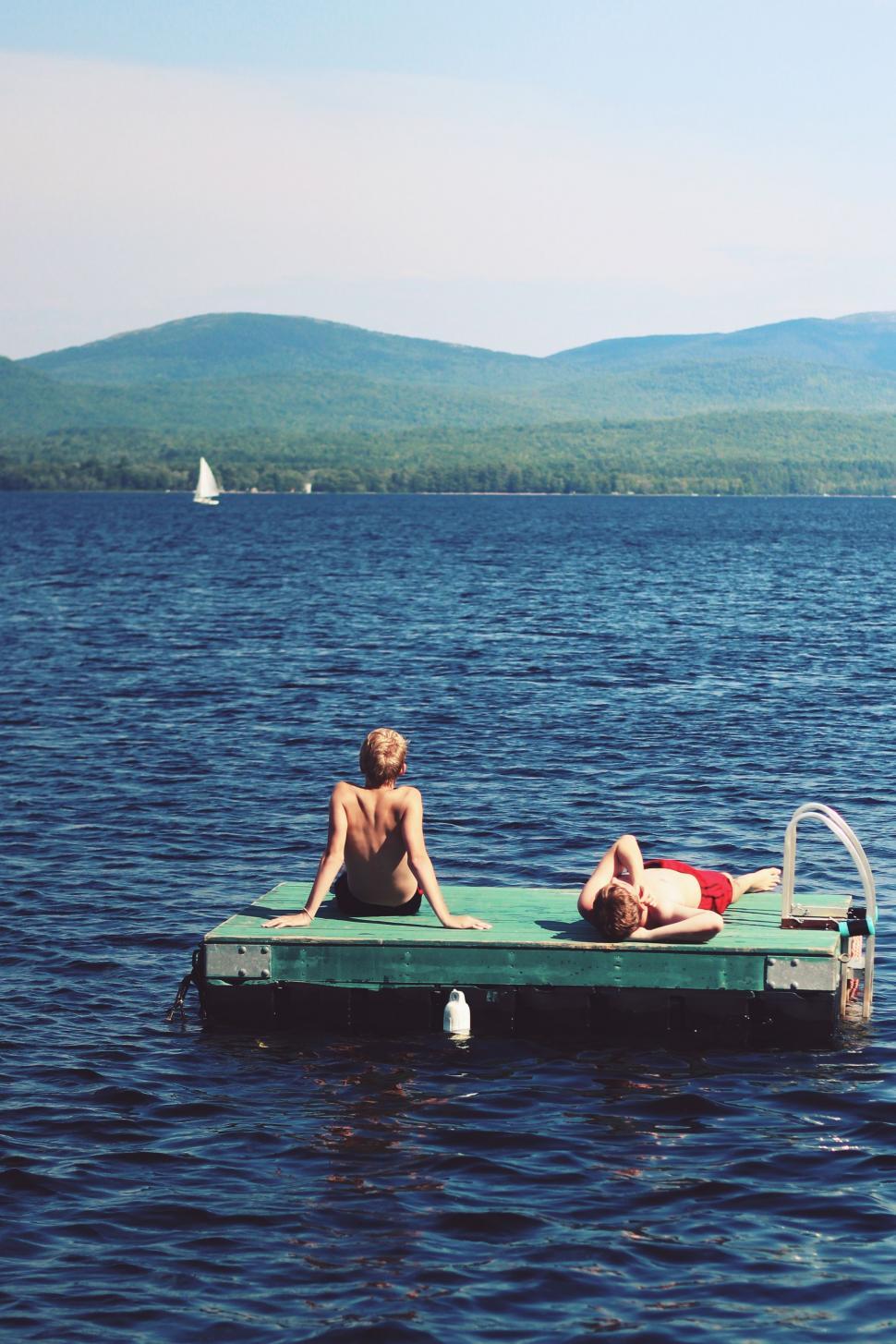 Free Image of Two men relaxing on lake  