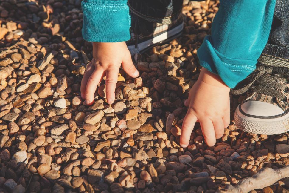 Free Image of Child Playing with Pebble Stones 