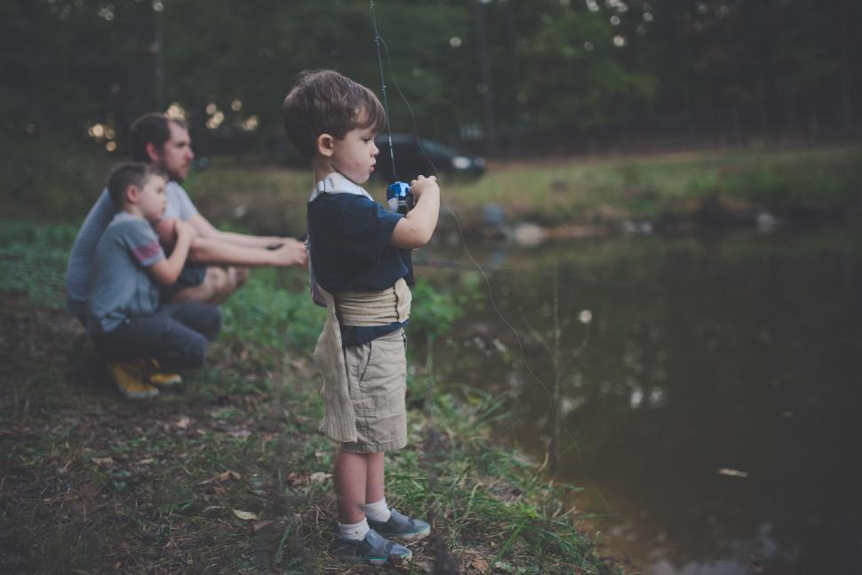 Free Image of Little boy fishing with family by the lake 