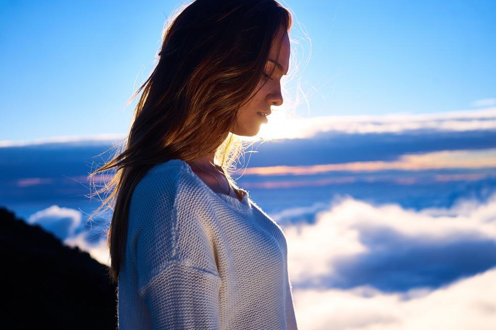 Free Image of Side View of Young Woman with white clouds  